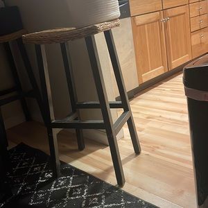 Two bar stools with woven tops.